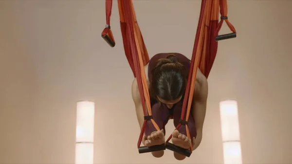 Chica practicando yoga antigravedad en el estudio. Señora estiramiento del cuerpo en hamaca — Foto de Stock