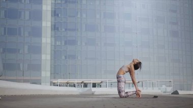 Caddede deve pozu veren bir kadın. Şehir caddesinde vücut geren bir kız