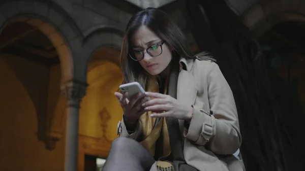 Estudante lendo más notícias no telefone. Empresária trabalhando no celular fora — Fotografia de Stock