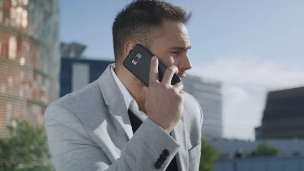 Empresario conversando por teléfono en la calle. Ejecutivo hablando en smartphone —  Fotos de Stock