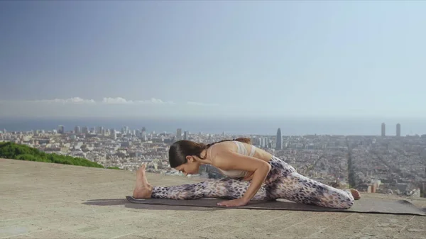 Йога-жінка, що робить йогу на відкритому повітрі. Фітнес леді розтягує тіло. — стокове фото