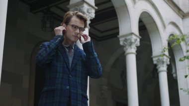 Dışarıda kablosuz kulaklık kullanan bir öğrenci. İş adamı kulaklıkla müzik dinliyor.