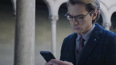 Öğrenci cep telefonundan kötü haberler okuyor. Akıllı telefon üzerinde çalışan bir işadamı