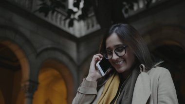 Üniversitede akıllı telefondan konuşan bir öğrenci. İş adamı dışarıda telefonla arıyor.