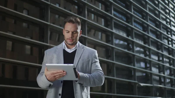 Geschäftsmann arbeitet an digitalem Tablet auf der Straße. Arbeiter benutzt Touchpad außen — Stockfoto