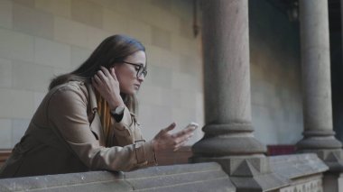 Öğrenci telefonda kötü haber okuyor. İş kadını açık havada akıllı telefon kullanıyor.