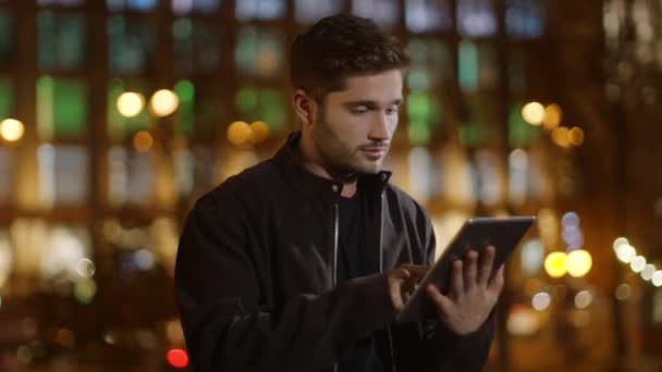 Ruhiger Mann beim Internetsurfen auf dem Tablet. Entspannter Typ, der draußen Tablet-Bildschirm berührt — Stockvideo