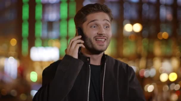 Hombre entusiasta hablando de teléfono móvil al aire libre. Chico feliz expresando placer . — Vídeos de Stock