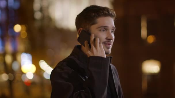 Um homem alegre a atender um telefonema na rua. Bonitão falando telefone celular . — Vídeo de Stock