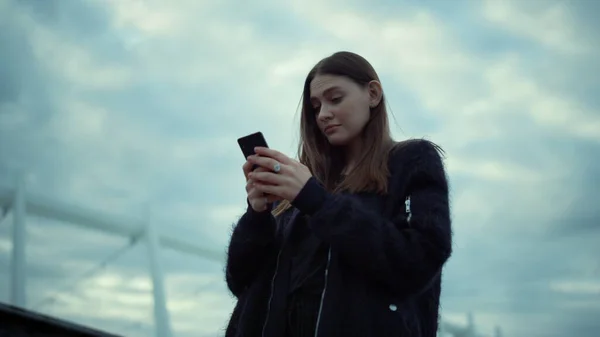 Menina lendo boas notícias na tela do smartphone na rua. Mulher usando telefone — Fotografia de Stock