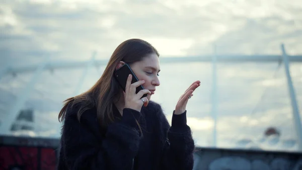 女性は通りでスマートフォンで話している。呼び出しのための携帯電話を使用して魅力的な女の子 — ストック写真