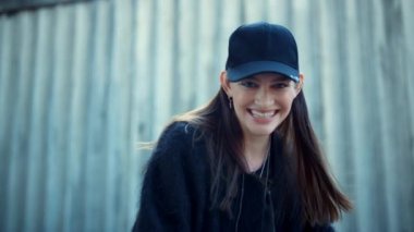 Şehir sokağında kameraya poz veren mutlu kız. Neşeli kadın dışarıda gülüyor.