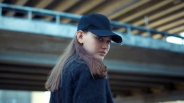 Şehir sokağında kameraya poz veren bir kız. Sokakta duran şık bir kadın