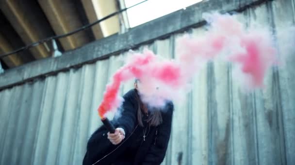 Дівчина махає димовою бомбою на камеру. Жінка протестує на вулиці з вогнем диму — стокове відео