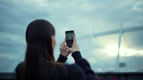 Mujer tomando fotos en el celular de la calle. Chica morena usando smartphone — Vídeo de stock