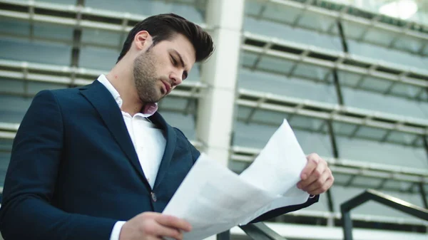 Portrait businessman looking at papers. Man standing with documents outside — Stock Photo, Image