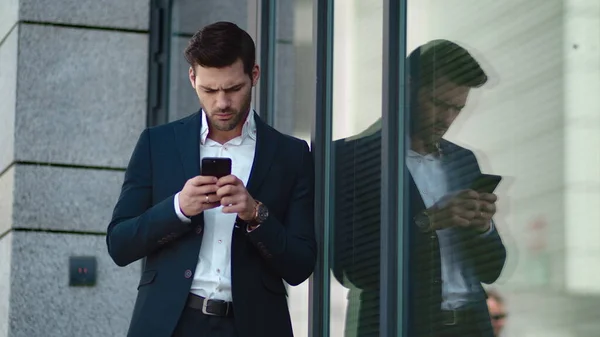Closeup businessman standing near building. Businessman using smartphone outside — Stock Photo, Image