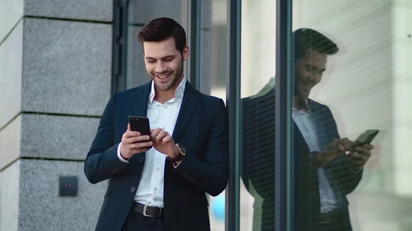 Closeup man standing in black suit at street. Businessman using smartphone — Stock Photo, Image