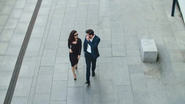 Top vista alegre casal andando na rua. Casal de negócios sorrindo ao ar livre — Fotografia de Stock