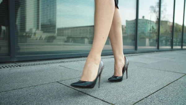 Primeros pies de mujer caminando por la calle. piernas de mujer caminando en zapatos de tacón alto — Foto de Stock