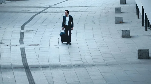 Closeup businessman walking with luggage. Man checking time on wristwatch