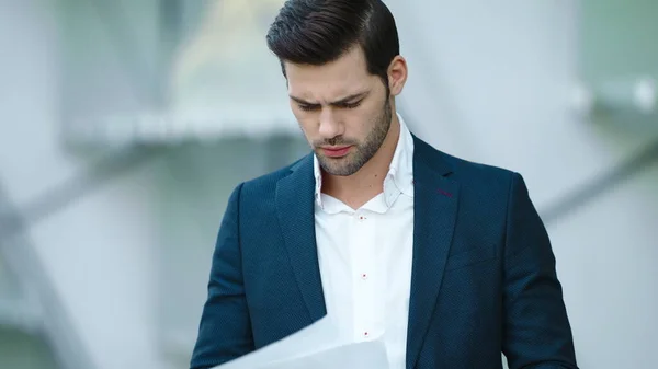 Portrait businessman looking at documents. Man standing with documents outdoors — Stock Photo, Image