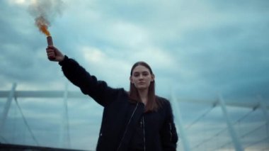 Elinde sis bombasıyla sokakta protesto yapan bir kız. Elinde sis bombası tutan kadın.