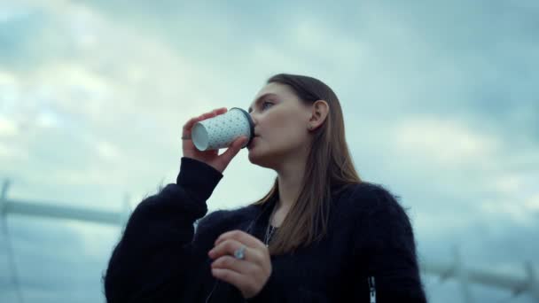 Flicka drickande ta bort kaffe på gatan. Kvinna kontrollerar tiden på armbandsur — Stockvideo