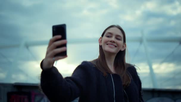 Holka bere selfie na smartphone v moderním městě. Šťastná žena pomocí mobilního telefonu — Stock video