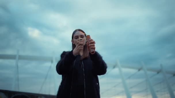 Chica encendiendo una bomba de humo con encendedor en la calle. Mujer mirando granada de humo — Vídeos de Stock