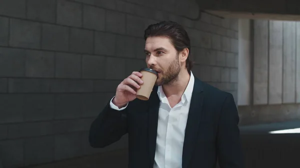 Business man drinking coffee to go outdoors.Male professional standing on street