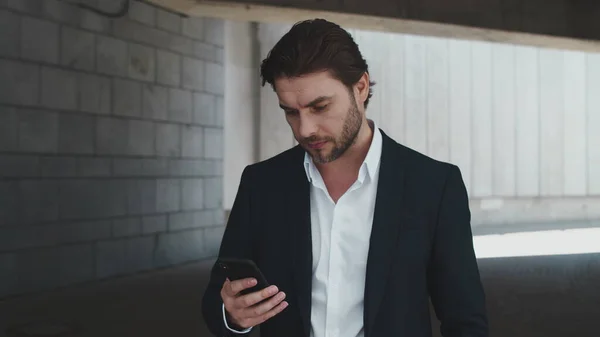 Porträt eines aufgeregten Geschäftsmannes, der gute Nachrichten auf dem Smartphone an der Stadtstraße liest — Stockfoto