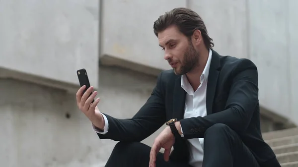 Affärsman som har videochatt på mobiltelefonen.Entreprenör viftar med handen framför kameran — Stockfoto