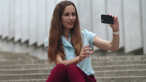 İş kadını akıllı telefondan selfie çekiyor. Dışarıda dudaklarını büzen bir kadın — Stok fotoğraf