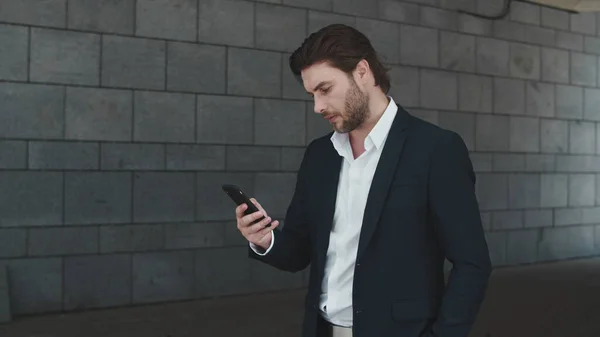 Geschäftsmann tippt auf dem Smartphone auf der Straße. Aufreger feiert Erfolg — Stockfoto