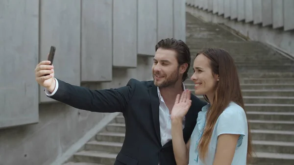 Colegas charlando en línea en el teléfono inteligente al aire libre. Hombre y mujer usando el teléfono celular — Foto de Stock