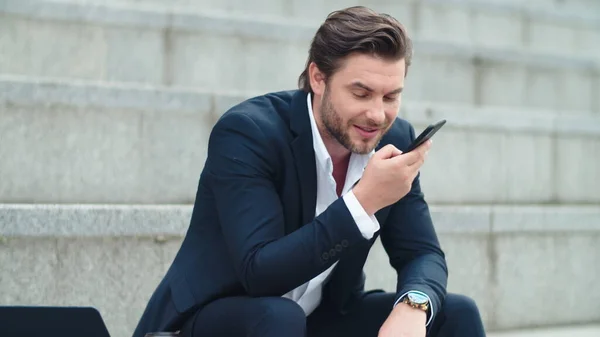 Empresário falando em alto-falante de telefone na cidade. Homem gravando mensagem de voz — Fotografia de Stock