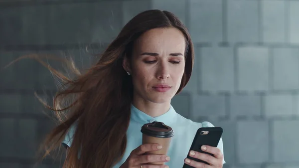 Mujer de negocios usando smartphone en la ciudad. Gerente de pie en la calle con café — Foto de Stock