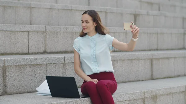 Geschäftsfrau macht Selfie mit dem Smartphone. Arbeiter zeigt Daumen hoch vor Kamera — Stockfoto