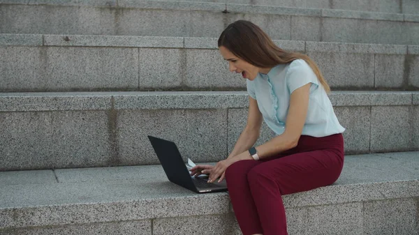 Geschäftsfrau liest gute Nachrichten am Laptop. Arbeiter feiern Erfolg in der Stadt — Stockfoto