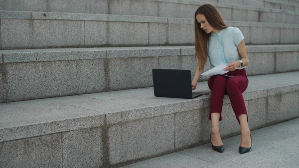 Geschäftsfrau tippt auf Laptop in der Stadt. Manager, der mit Finanzdokumenten arbeitet — Stockfoto