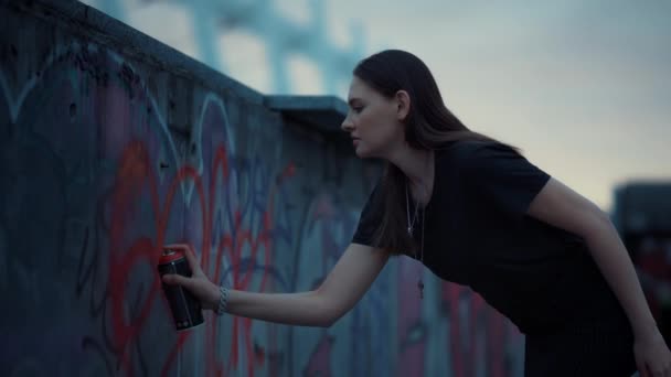 A lány graffitit rajzol festékszóróval a falon. Aeroszolos festéket használó nő — Stock videók