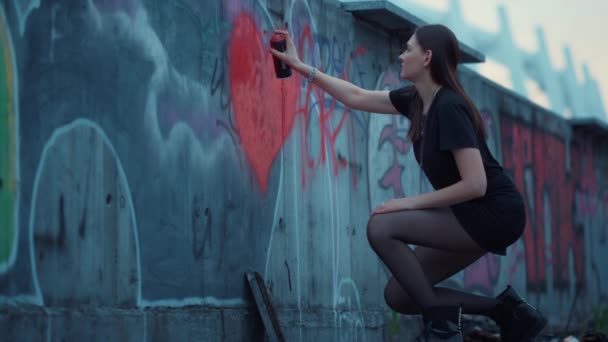 Chica pintando corazón en la pared con aerosol bottle.Woman dibujo graffiti en el edificio — Vídeos de Stock