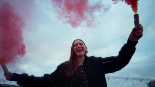 Mädchen bewegen Rauchbomben in den Händen. Frau posiert auf Straße in buntem Rauch — Stockvideo