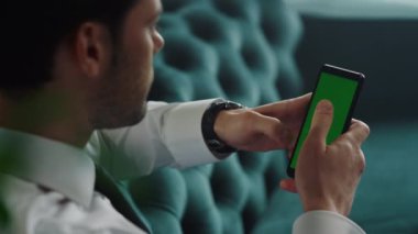 İş adamı ofisteki akıllı telefondan internete bakıyor. Cep telefonu kullanan işçiler