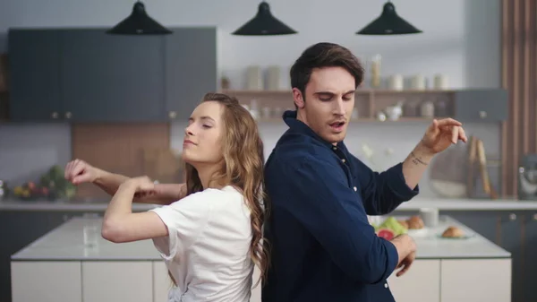 Onnellinen mies ja nainen tanssivat takaisin kotiin keittiössä hidastettuna . — kuvapankkivalokuva