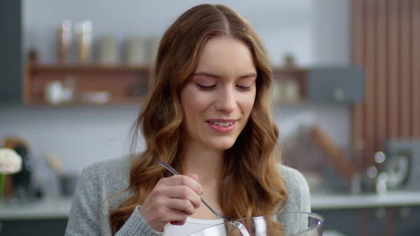 Muotokuva hymyilevä nainen syö tuoretta salaattia kotona keittiössä. Kasvisruoka — kuvapankkivalokuva