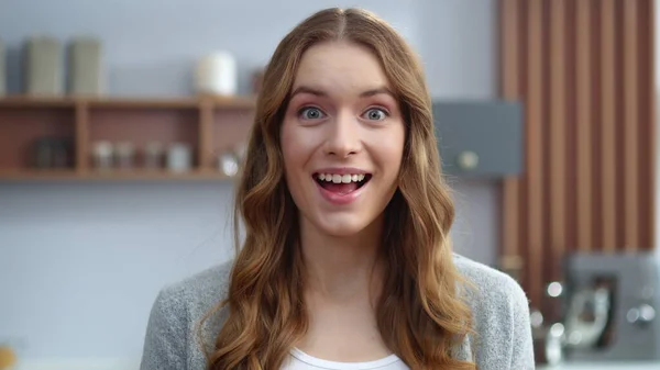 Smiling girl showing chocolate bar at home kitchen. Woman looking camera indoors — Stock Photo, Image