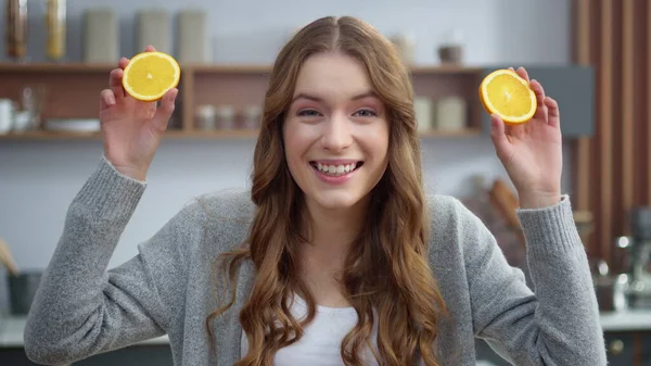 Følelsesmessig jente som lager grimaser med appelsiner på kjøkkenet. Kvinner som forandrer følelser – stockfoto