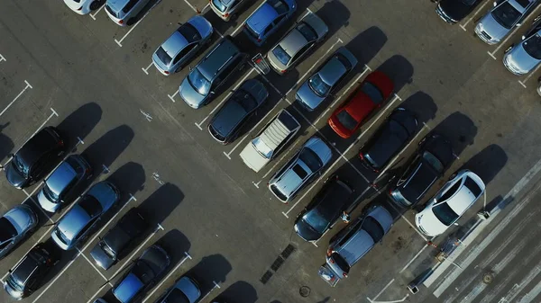 Aerial view people walking at parking. Drone footage man moving trolley